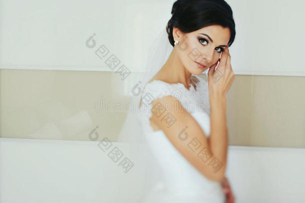 令人晕倒的黑头发的妇女新娘相貌纤弱的使摆姿势采用白色的房间