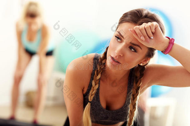 疲倦的和浑身出汗的但是满意的女人后的锻炼在健身房