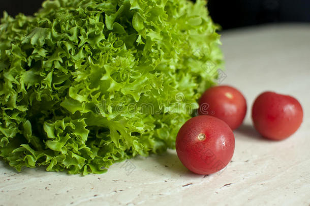 束关于生的有机的绿色的苦苣沙拉和两个番茄