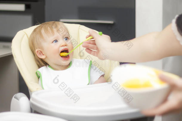 幸福的蹒跚行走的人一次采用小孩吃饭时所用的高脚椅子和eat采用g粥.<strong>婴儿</strong>草地