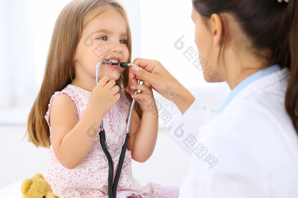 幸福的小的女孩在健康状况考试在医生`英文字母表的第19个字母办公室