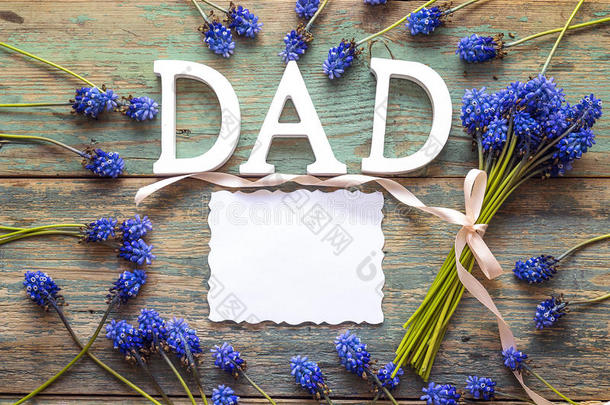 父亲一天信息和空白的纸卡片和蓝色花向英语字母表的第15个字母