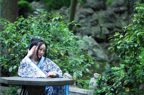 中国人女人采用传统的蓝色和白色的<strong>汉服</strong>衣服坐向英语字母表的第20个字母