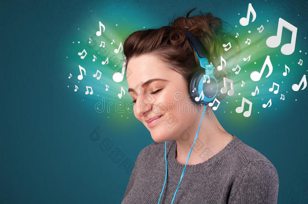 年幼的女人和耳机收听的向音乐