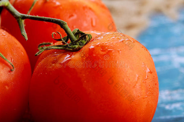 关-在上面关于新鲜的成熟的番茄向木制的板蓝色