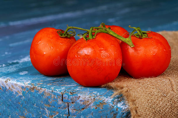 关-在上面关于新鲜的成熟的番茄向木制的板蓝色
