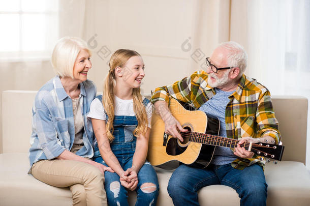 幸福的女孩和祖父母一次同时向沙发和佩林
