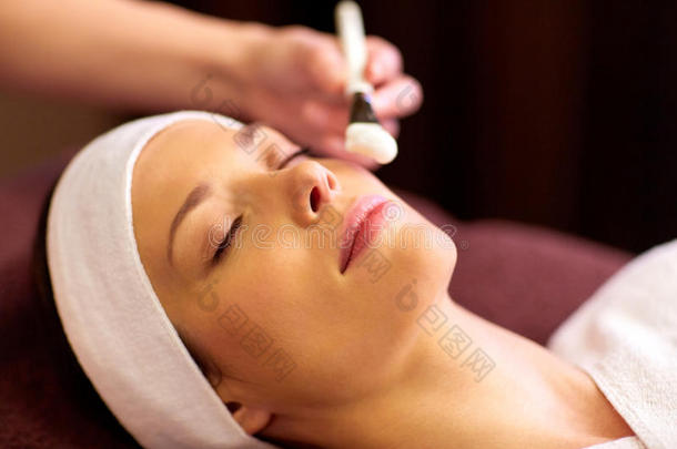 美容师应用面部的面具向女人在休闲健身中心