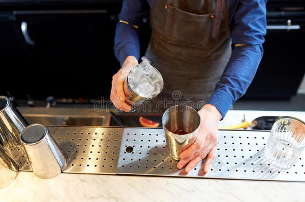 酒吧间销售酒精饮料的人和冰和<strong>摇动</strong>者在鸡尾酒条