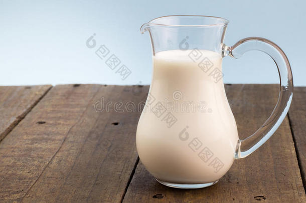 新鲜的全部的奶采用玻璃n.大罐向粗糙的木制的表背景