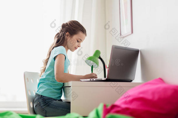 女孩和便携式电脑<strong>文字</strong>向笔记簿在家