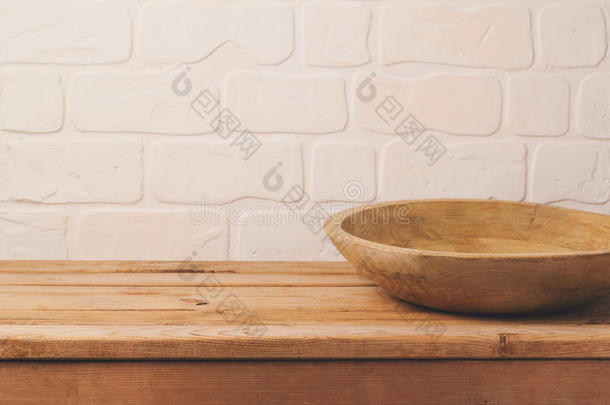 空的木制的甲板表和盘子越过砖墙