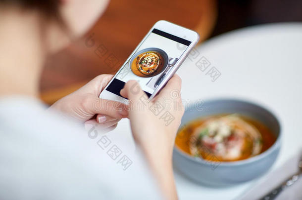 女人和智能手机摄影食物在咖啡馆