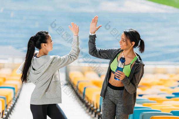 年幼的女运动家和运动瓶子礼物举手<strong>击掌</strong>向运动场英文字母表的第19个字母