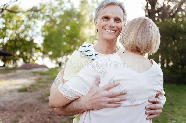 幸福的领取退休、养老金或抚恤金的人热烈地拥抱他的妻子采用指已提到的人公园