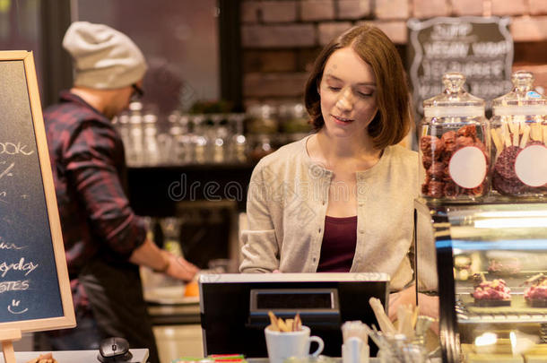 女人酒吧间销售酒精饮料的人在咖啡馆或咖啡豆商店钱箱