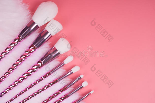 化妆刷子放置向红色的粉红色的彩色粉笔背景