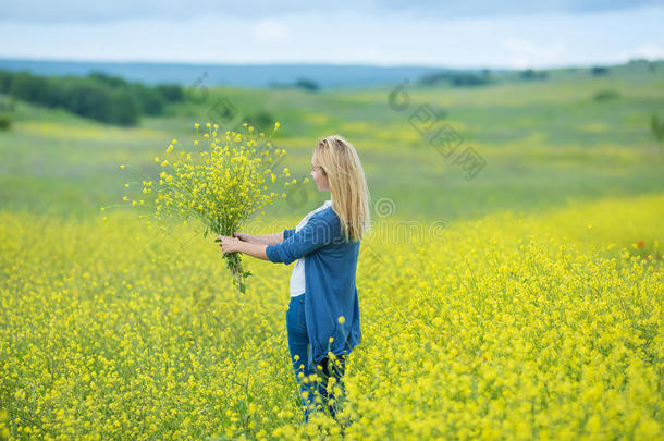 真正的漂亮的女士女人采用草地关于黄色的花sniff采用gfloodlight泛光照明