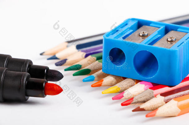 有色的铅笔和蓝色铅笔卷笔刀向白色的背景