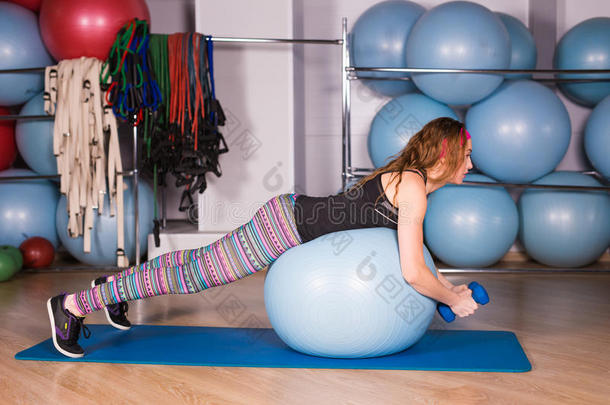 年幼的像运动家的女人采用健身房do采用g健康锻炼和蓝色球