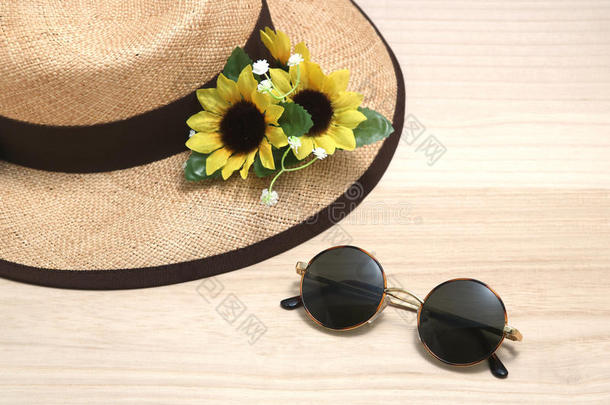 太阳镜和稻草帽子和向日葵向木材.