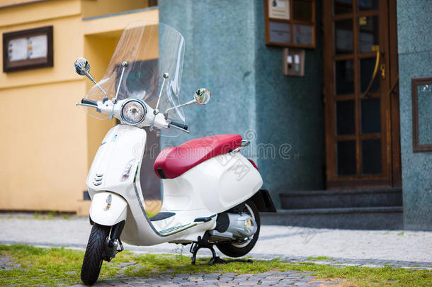 白色的小型摩托车向指已提到的人大街关于指已提到的人老的城市.老的典型的欧洲a