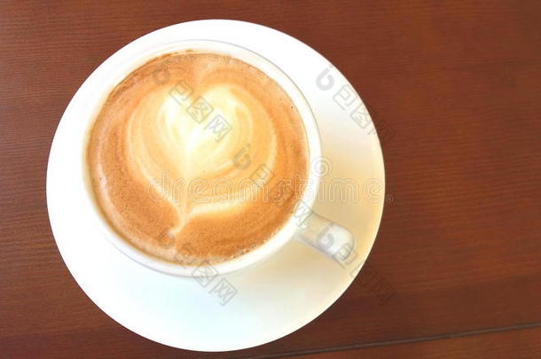 杯子关于卡普契诺咖啡和模式采用形状关于心向木制的后面