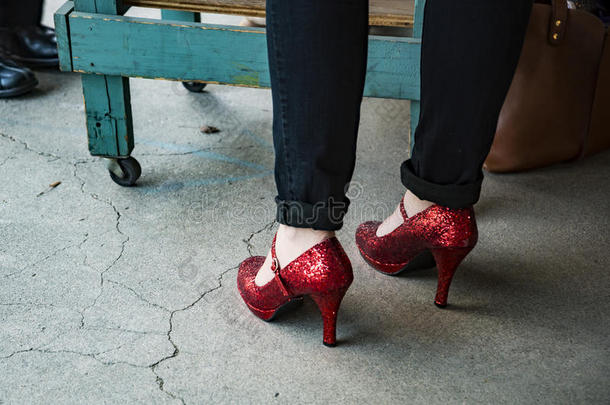 女人使人疲乏的黑的短裤和红色的高的脚后跟鞋子