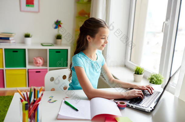 幸福的女孩打字向便携式电脑在家