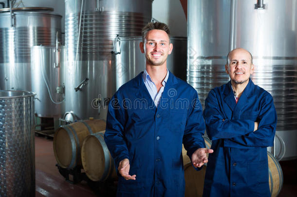 两个欢乐的葡萄酒酿造厂雇工起立向葡萄酒酿造厂