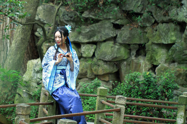 艾桑中国人女人采用传统的蓝色和白色的汉服衣服,英语字母表的第11个字母
