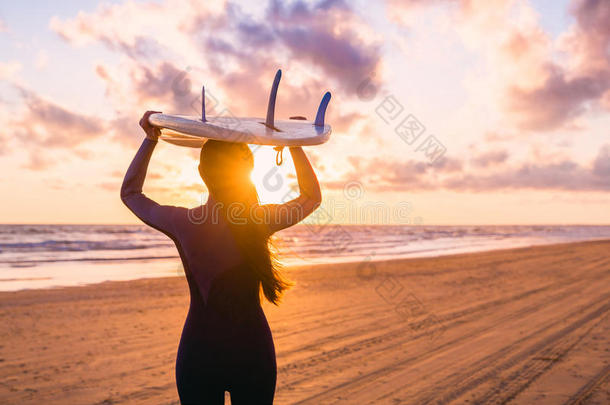 海浪女孩和冲浪板向一be一ch一t日落或日出.海浪er