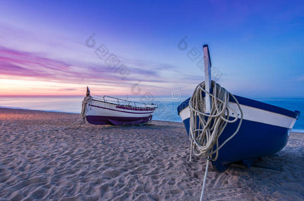 捕鱼小船向沙的海滩在怀旧的日出