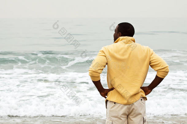 非洲的美国人男人步行向指已提到的人海滩.
