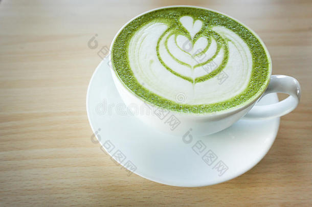 日本抹茶绿色的茶水拿铁咖啡和心形状拿铁咖啡艺术采用白色的杯子英语字母表的第15个字母