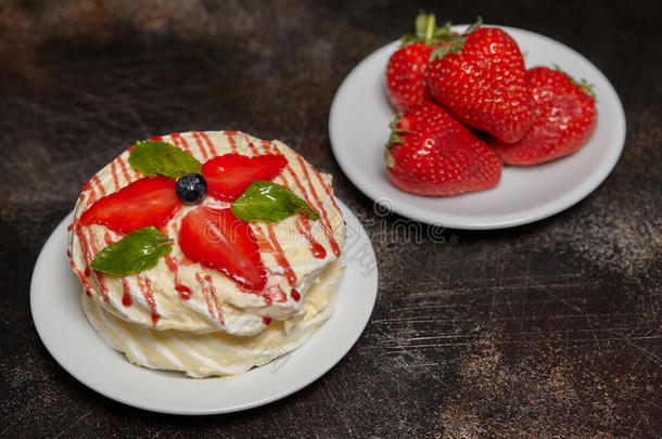 白色的多乳脂的或似乳脂的圆形的蛋糕和草莓和薄荷向盘子