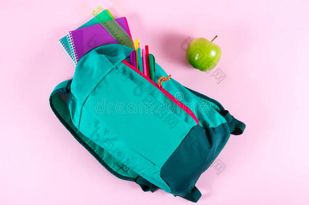 背包和学校文具向粉红色的背景