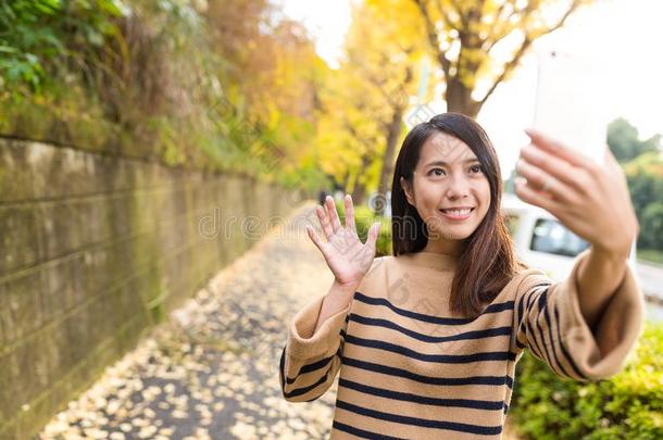 女人迷人的<strong>生命</strong>的<strong>生命</strong>和蜂窝式便携无线电话在大街和银杏树树