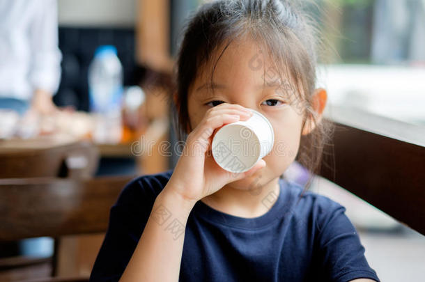 亚洲人小孩喝饮料水从纸杯子