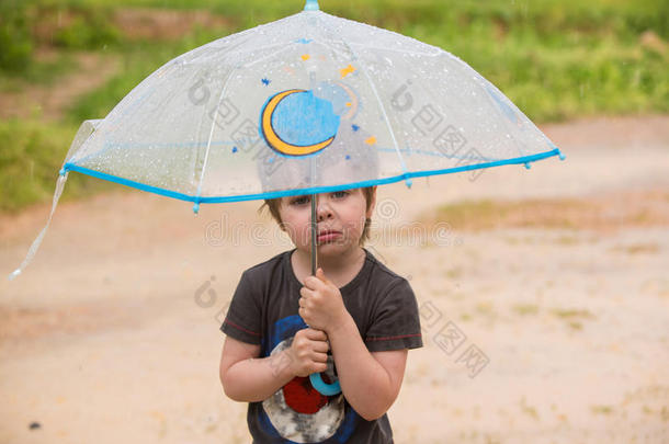小的男孩在下面雨伞