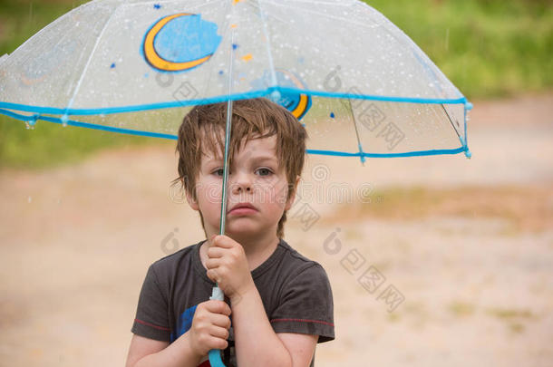 小的男孩在下面雨伞