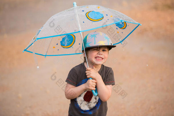 小的男孩在下面雨伞