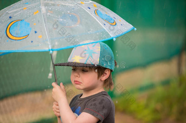 小的男孩在下面雨伞