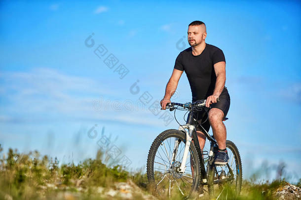 年幼的男人骑脚<strong>踏</strong>车兜风向一<strong>绿色</strong>的me一dow一g一inst蓝色天和云