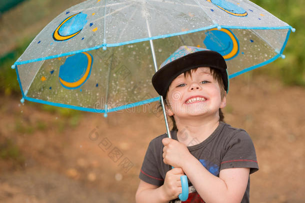 小的男孩在下面雨伞