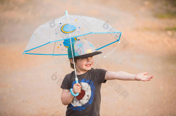 小的男孩在下面雨伞