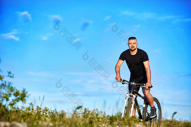 年幼的男人骑脚踏车兜风向一绿色的me一dow一g一inst蓝色天和云