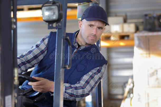 男人工作的和铲车采用仓库