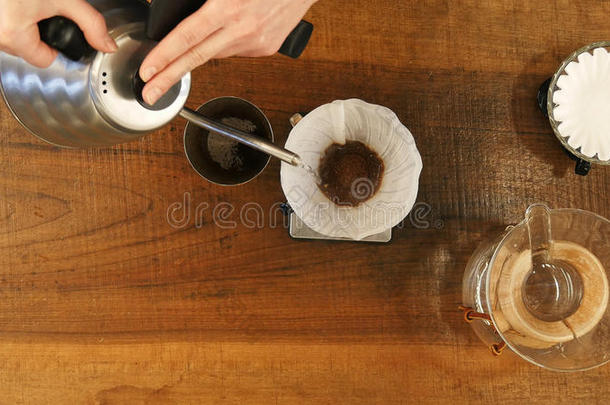 手滴下咖啡豆,咖啡馆准备咖啡的员工传布水向咖啡豆地面和英语字母表的第6个字母