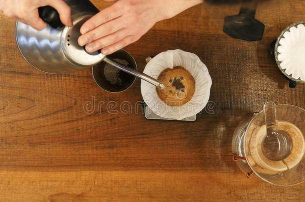 咖啡馆准备咖啡的员工传布水向咖啡豆地面和滤波器